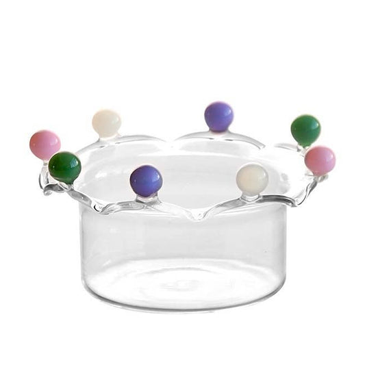 A clear borosilicate glass serving bowl, sculpted with a dramatic wavy, crown-like rim. The rim is adorned with alternating, colorful solid glass beads (pink, dark green, cream, purple), creating a playful and elegant dessert or candy dish