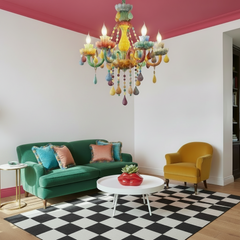 Colorful chandelier hanging in a living room with a couch, coffee table, and decorative items.