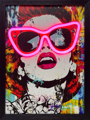 A vibrant, framed pop art portrait of a woman with graphic, floral neck tattoos and bold pink lips. Her exaggerated cat-eye sunglasses are outlined by a bright, functional pink LED neon light, creating an electric focal point on the colorful, abstract splatter background.